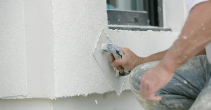 Peintre en bâtiment posant du crépi