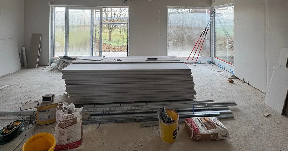 Plaques de plâtre posées au sol sur un chantier de plâtrerie avant montage des cloisons