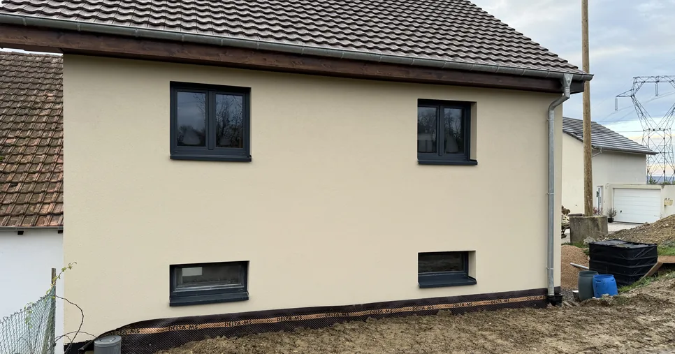 Même façade après isolation extérieure dans le Sundgau, crépi de finition beige et fenêtres anthracite
